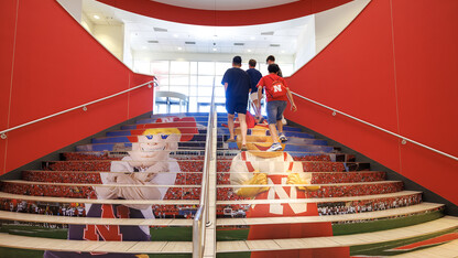 Students walk up the stairs in Nebraska Union Aug 16. The stairs were updated with new decals depicting Herbie Husker and Lil Red.