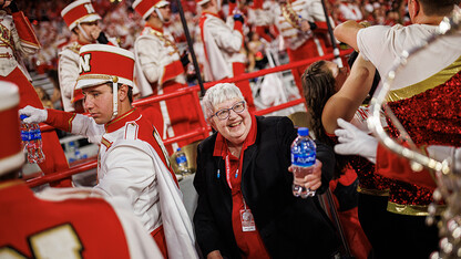 Rose Johnson with the Cornhusker Marching Band hands out water to the band members as they return to the stands following the half time show during the NU v. Northern Illinois game.