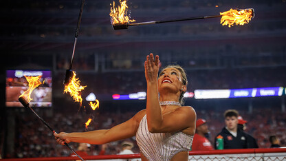 Steffany Lien twirls batons of fire at the Husker football game halftime show.