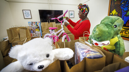 Domonique Cudjo, assistant director, Gender and Sexuality Center, attaches a gift tag to a bicycle being given to a little Husker.