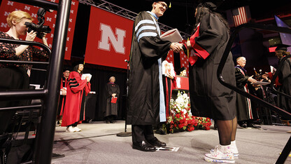 Crandall Blake receives her diploma from acting dean Nicholas J. Pace. Blake is wearing high tops she had her kindergarten students she student taught sign so they could walk on stage with her.