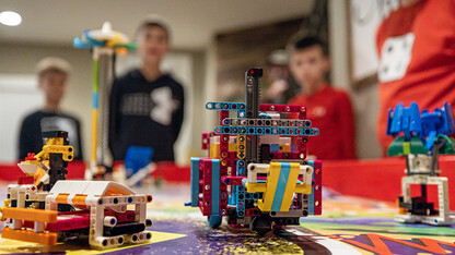 Robots made from Lego bricks sit on a FIRST LEGO League game board.