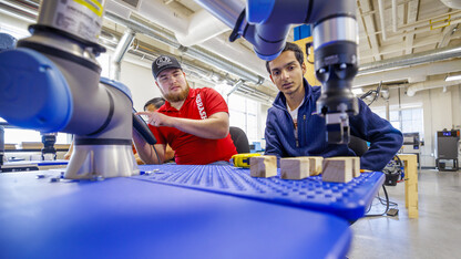 Jacob Hansen, with ALA engineering and a Nebraska alumni, and Kunjan Theo Joseph with the UNL MAARS Lab, work at making their robotic arm program stack blocks.  The programming would simulate a larger robotic arm stacking pallets. Nebraska Innovation Studios is working with robotic arms and teaching students and local industry people how to use them.