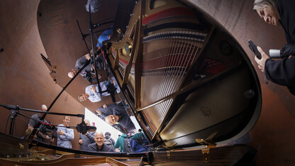 Paul Barnes, Marguerite Scribante Professor of Piano in the Glenn Korff School of Music, is reflected in the piano lid as spectators pass through the sculpture.