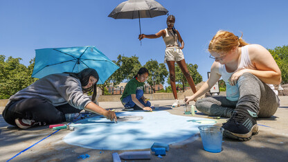 Evelyn Whitlock, Claudia Figueroa and Sarah Paarden work on a chalk painting as part of the 6-week summer Upward Bound program. 