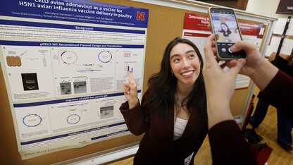 Hamelynn Harzman of Iowa State University poses for a photo taken by her poster session neighbor Adrian Dunivan of the Universitiy of Missouri during the Nebraska Summer Research Symposium on Aug. 6. 