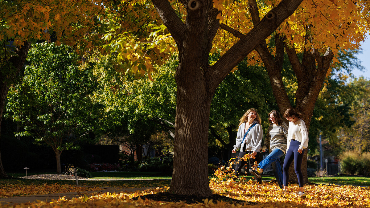 Riley Bruno (center) kicks up leaves as she walks across campus with Emily Hodgin (left) and Natalie Altenhoff on Oct. 25.