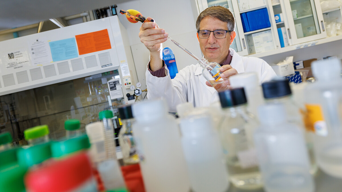 Edgar Cahoon stands inside his laboratory in Beadle Hall at the University of Nebraska–Lincoln. Scientific equipment and research materials are visible in the lab around him.