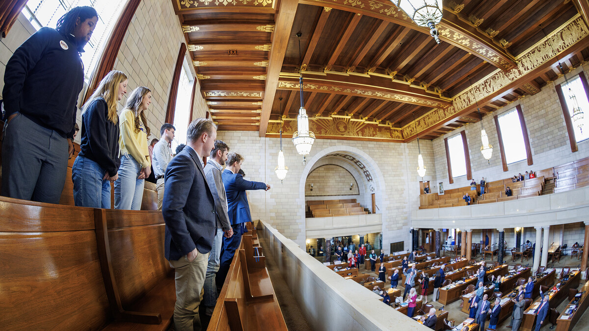 Members of the University of Nebraska community stand together in the Warner Legislative Chamber in the Nebraska State Capitol on April 2.