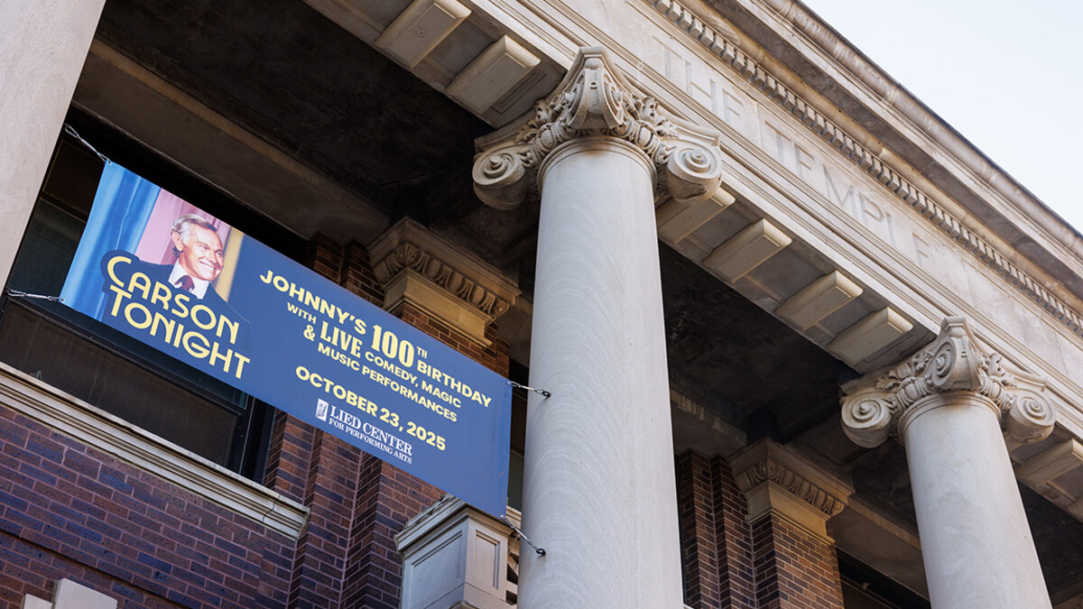 A sign advertising Carson Tonight hangs from the Temple Building. The event celebrates University of Nebraska alum Johnny Carson’s 100th birthday.