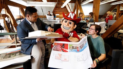 Herbie Husker examines building plans in an Architecture Hall lab space. This image is part of the Nebraska Alumni Association's 2018 calendar.