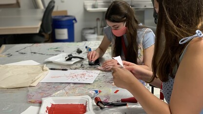 Participants make stenciled fabric designs.