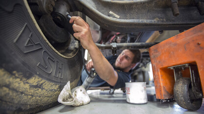 Jacob Green, a mechanic II, lubricates the chassis of a university delivery truck at the Transportation Services garage on City Campus.