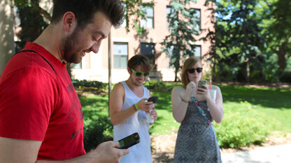 UNL students (from left) Thomas Kasper, John Sanders and Hanna Barnett battle in a Pokémon Go gym location near Sheldon Museum of Art on July 13. The game, which launched July 6, has quickly become one of the most popular apps available to smartphone users. 