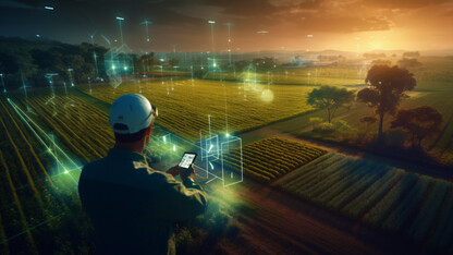 A farmer is shown using a cell phone near a corn field, with connections to cell towers shown in the atmosphere