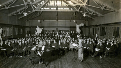 Carrie Belle Raymond (standing, at right) directs the university chorus in April 1922 in what is today the Architecture Hall library reading room. Raymond was hired in 1894 to direct the university chorus and orchestra. She also taught music until her death in 1927. The first women's dormitory, Raymond Hall, was named for her in 1931. This image is included in Kay Logan-Peters' new book, "University of Nebraska–Lincoln."