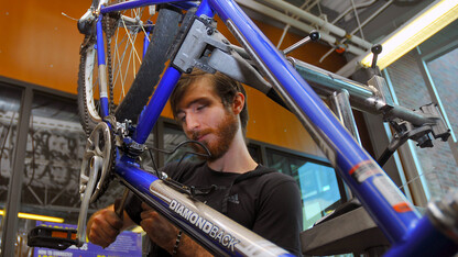 Seth Thacker-Lynn finishes a repair in UNL's bike shop. The repair shop is part of the Outdoor Adventures Center.