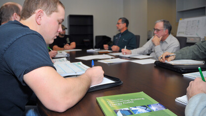 UNL engineering students write down answers during an interview with Kirk Conger. The students are conducting energy audits of UNL buildings as part of a pilot course in engineering.