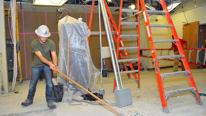 Josh Moser of Ayars and Ayars sweeps inside the space that will be Nebraska Union's redesigned welcome desk and Caffina Café. The space is scheduled for completion in early January. (© 2013, The Board of Regents of the University of Nebraska. All rights reserved.)