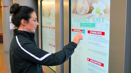 Kaylie Martens, a senior nutrition, exercise and health sciences major, uses the new digital touchscreen in the Campus Rec Center on City Campus. The boards are part of a campuswide initiative.