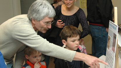 Rob Skolnick, a preparator with the University of Nebraska State Museum, explains the history of fossil puke to two children during the 2011 Dinosaurs and Disasters event in Morrill Hall.