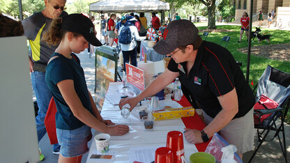 Pictured is Extension Associate Becky Schuerman (right) who serves as Extension’s statewide domestic water and wastewater coordinator, presenting aquifer in a cup. 