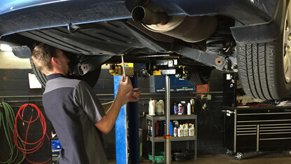 A mechanic at Auto Connection in Lincoln searches for a kitten that crawled into the undercarriage of Ozgur Araz's car on Sept. 1. The kitten was rescued and is available through UNL's Husker Cats program.