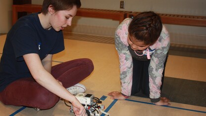 Computing for All member Allison Buckley helps a Girl Scout program a robot at last month's Girl Scout camp.