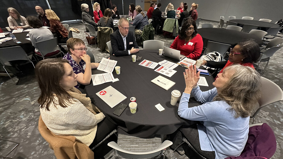 UNL administrators, faculty and staff sitting around a table discussing the future of the university.