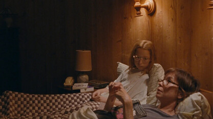 Image of a mom and daughter in bed from the movie "Janet Planet."