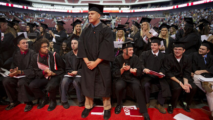 Students receiving military commissions stand to be recognized while others rise to cheer during the All-University Commencement at Pinnacle Bank Arena on Aug. 16.