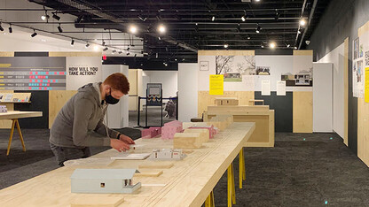 A student helps set up the NEw Attainable House exhibit