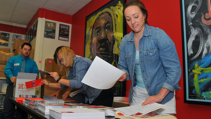 Nate Dederman (from left), Adam Lambert, Liz Roggasch and Maggie Schneider prepare information packets for UNL's New Student Enrollment, which opens June 9.