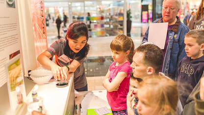 UNL student explains nanoscience to youth at 2014 NanoDays in Lincoln's Gateway Mall.
