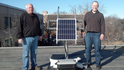 Rick Perk (left), assistant geologist, and Brian Wardlow, director of CALMIT and associate professor, stand with the PhenoCam on the roof of Hardin Hall. The camera is being moved to Nine Mile Prairie as part of a survey of North American landscapes.