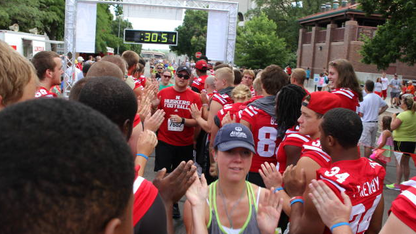 Husker football athletes greet runners at the end of the 2013 Uplifting Athletes Road Race. Registration is open for the 2014 race, which is July 20.