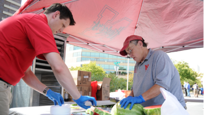 Tony Rathgeber and Dodie Fearing cut watermelon for the all-university picnic.