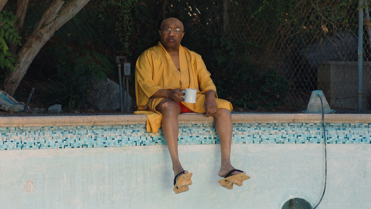 Swamp Dogg hangs out on the side of his pool as it's repainted.