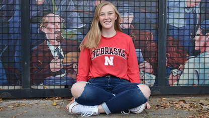 Julia Stephenson poses for a photo in front of a mural.