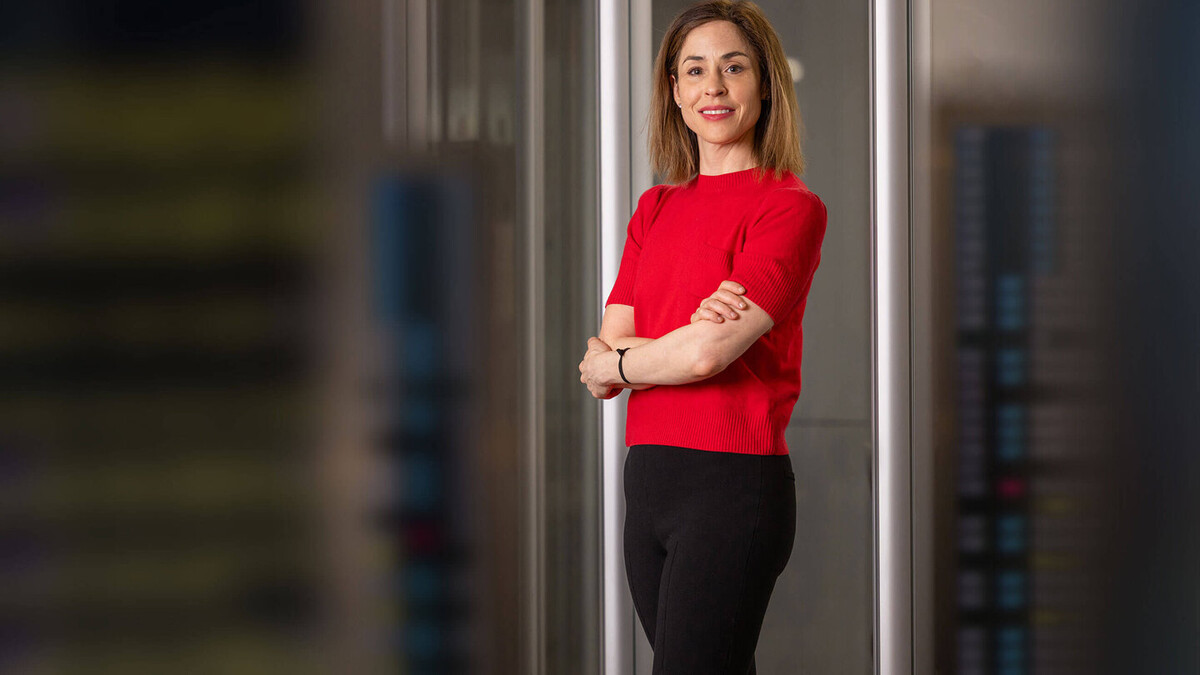 Elana Zeide wears a red shirt and is photographed in a doorway in the law school.