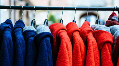 blue and red winter coats hanging on a rod