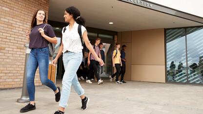 Students walk out of a school building.