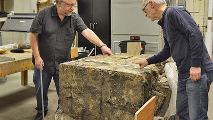 Professor of plant and ecosystem ecology Dave Wedin (left) and David Murphy, senior research architect at the Nebraska State Historical Society, with the sod wall. (Mekita Rivas | Natural Resources)