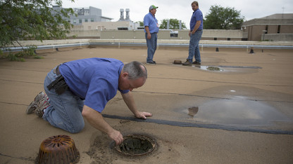 Maintenance employees work to fend off spring rains