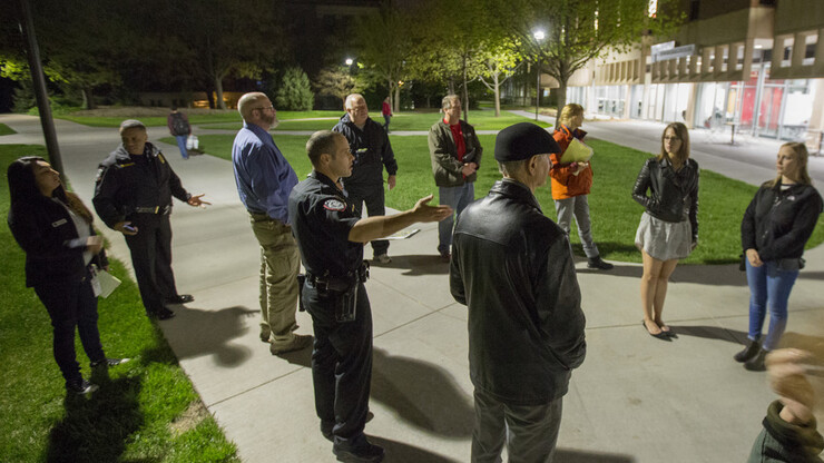 Capt. John Backer of the University Police Department (fourth from left) discusses lighting and landscaping improvements made to increase visibility on the plaza north of Love Library. The discussion was part of the university annual campus safety walk, w