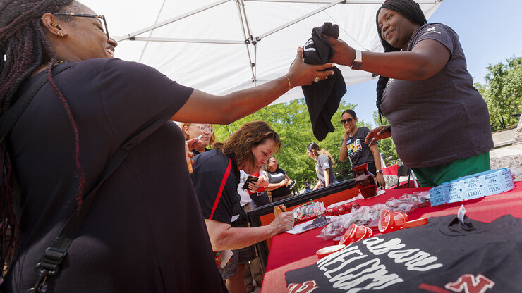 Jerri Harner, executive specialist with the Office of Diversity and Inclusion, hands out T-shirts to Huskers and community members who celebrated Juneteenth during the university’s observance on June 20, 2022 at the Nebraska Union Plaza.