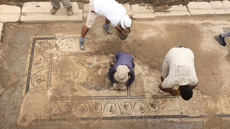 Turkish members of an excavation team led by Nebraska art history professor Michael Hoff sweep dirt away from a new mosaic discovered in August 2018. Courtesy photo. 