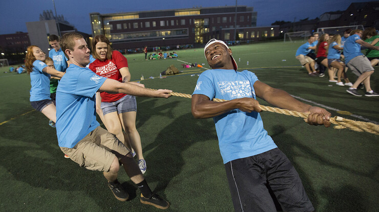 Quentin Hoover (in blue, from right) and Bob Kelly yell encouragement to each other as their team engages in a tug-of-war with other students. The event was part of the All-Learning Communities Welcome celebration held Aug. 20 on UNL's Mabel Lee Field.