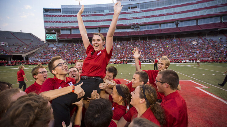 Lena Buckner, a sophomore from Lincoln, is lifted into the air by her fellow horn players after she won the annual march off competition during the Cornhusker Marching Band's exhibition performance Aug. 21 in Memorial Stadium.