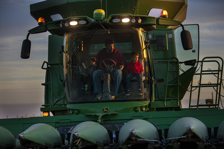 A farmer sits in his combine with his children as corn is harvested in Nebraska.